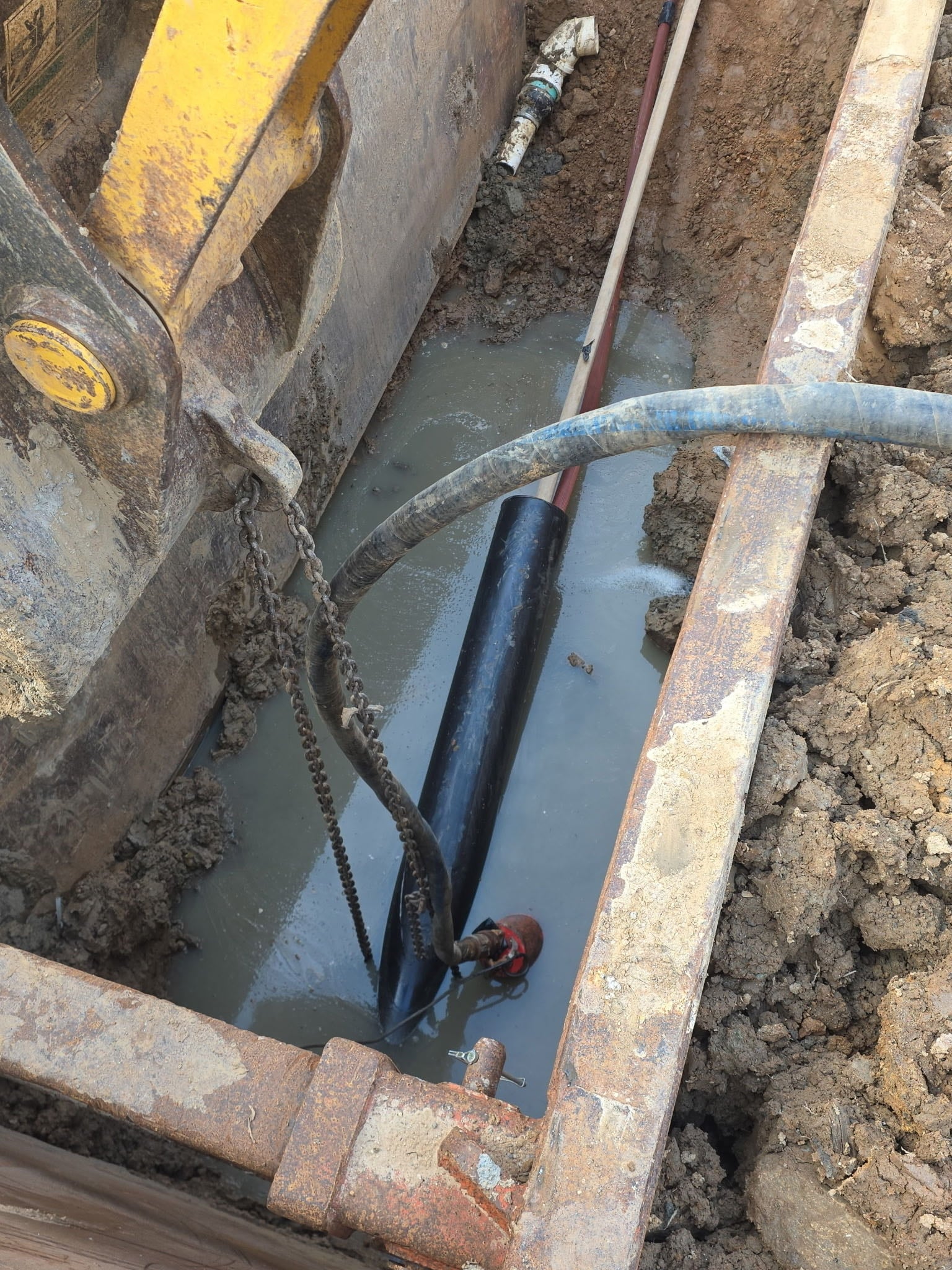 Pipe bursting in progress — new HDPE pipe being pulled through the existing line.